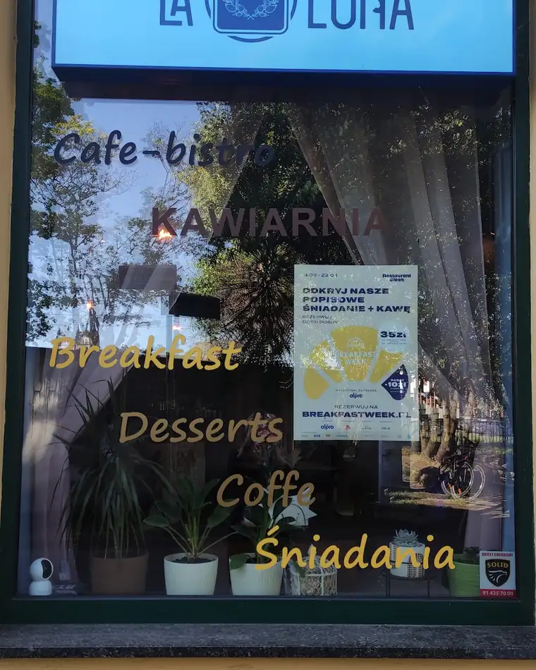 Okno La Luny z niebieskim szyldem i napisami Breakfast, Desserts, Coffee, Śniadania